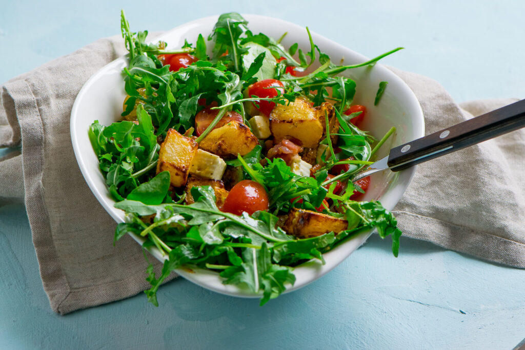 Leckerer Honig Senf Kartoffelsalat mit Rucola & Speck. Besonders lecker schmeckt der warme Kartoffelsalat mit frischem Salat und knusprigen Kartoffelecken,