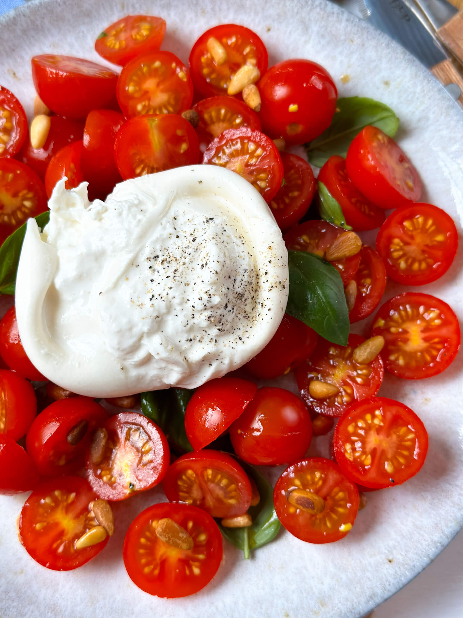 Rezept für köstlichen Tomatensalat mit Burrata und Pinienkernen Rezept für köstlichen Tomatensalat mit Burrata und Pinienkernen