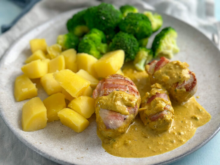 Zarte Schweinemedaillons im Speckmantel in köstlicher Currysoße